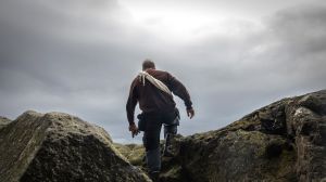 Jógvan Jón pokonujący skalne rumowisko – drogę , która prowadzi do jego domu na szczycie wyspy