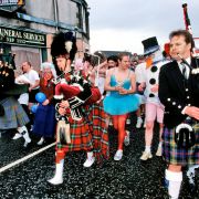 Szkoci bawią się na ulicach przy  akompaniamencie dudziarzy.