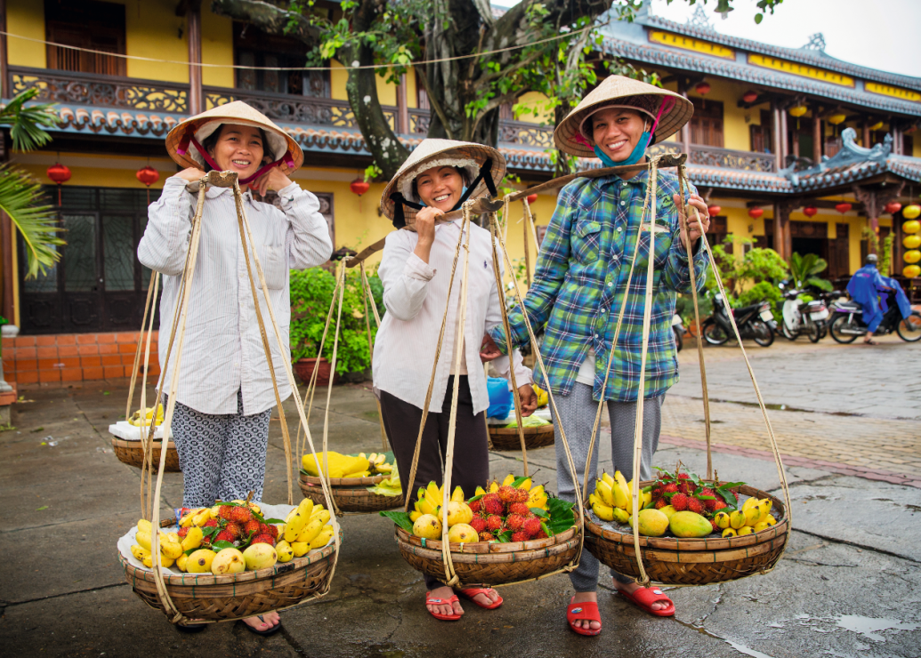 Uliczne sprzedawczynie owoców w Hoi An w tradycyjnych kapeluszach  nón lá. Wyplatane  z liści palmowych chronią przed słońcem i deszczem.