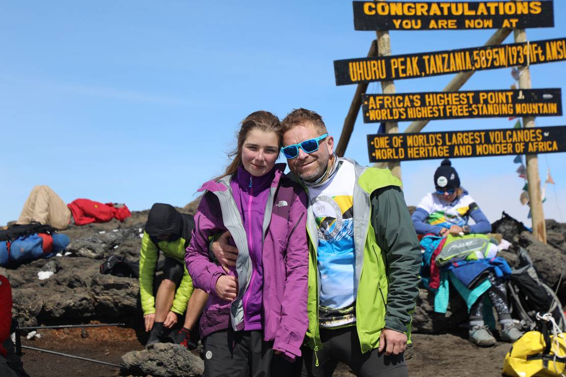 Natalia Gawron z tatą Michałem na szczycie Kilimandżaro. W tle biegacze szykują się do startu.