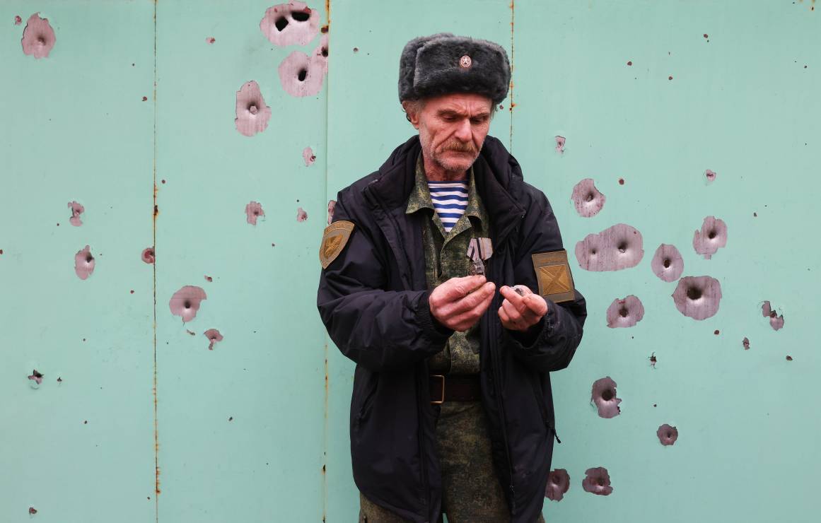mieszkaniec Gorłówki stoi na tle budynku, który został ostrzelany w wyniku ataku Rosjan, fot.  Alexander Ryumin\TASS via Getty Images