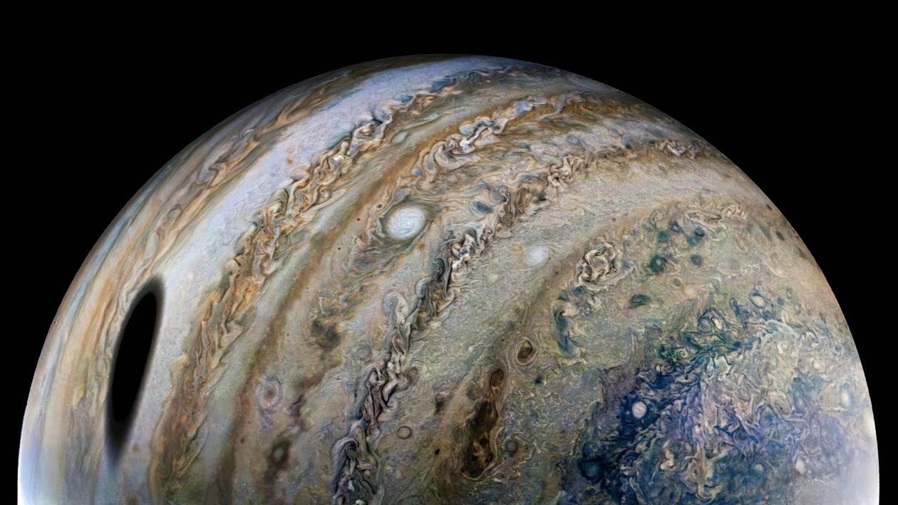Sonda kosmiczna Juno uchwyciła ten widok Jowisza podczas 40. bliskiego przelotu w pobliżu planety, do jakiego doszło 25 lutego 2022 roku. Duża, ciemna plama po lewej stronie to cień rzucony przez księżyc Jowisza, Ganimedesa.