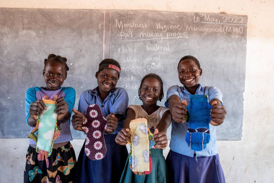 Dziewczynki w szkole w Zambii pokazują uszyte przez siebie podpaski. UNICEF wspiera Programy Zarządzania Zdrowiem Menstruacyjnym na całym świecie.