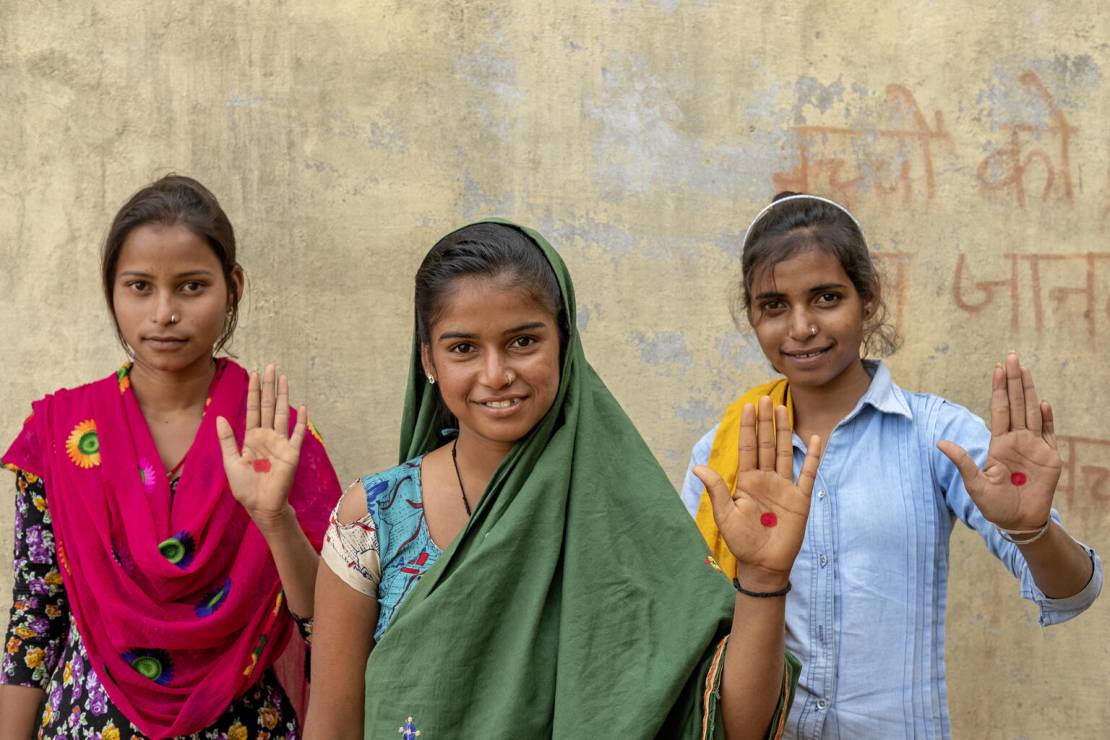 Indie. 16-letnie dziewczynki Veena Kumari, Bhavana Kumari i Santhosh Kumari pokazują czerwoną kropkę na dłoni - symbol budowania świadomości na temat menstruacji wśród społeczeństwa i walki z mitami i tabu o okresie