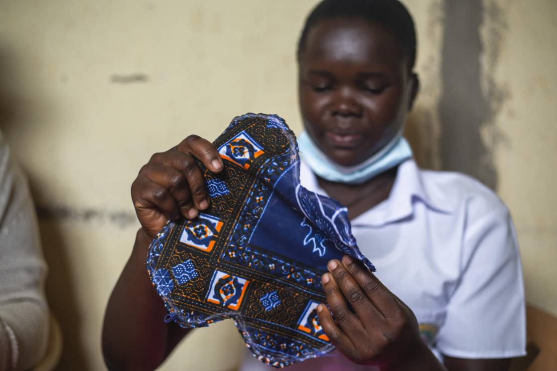 Uganda. 16-letnia Manguci Joana pokazuje uszytą przez siebie podpaskę.