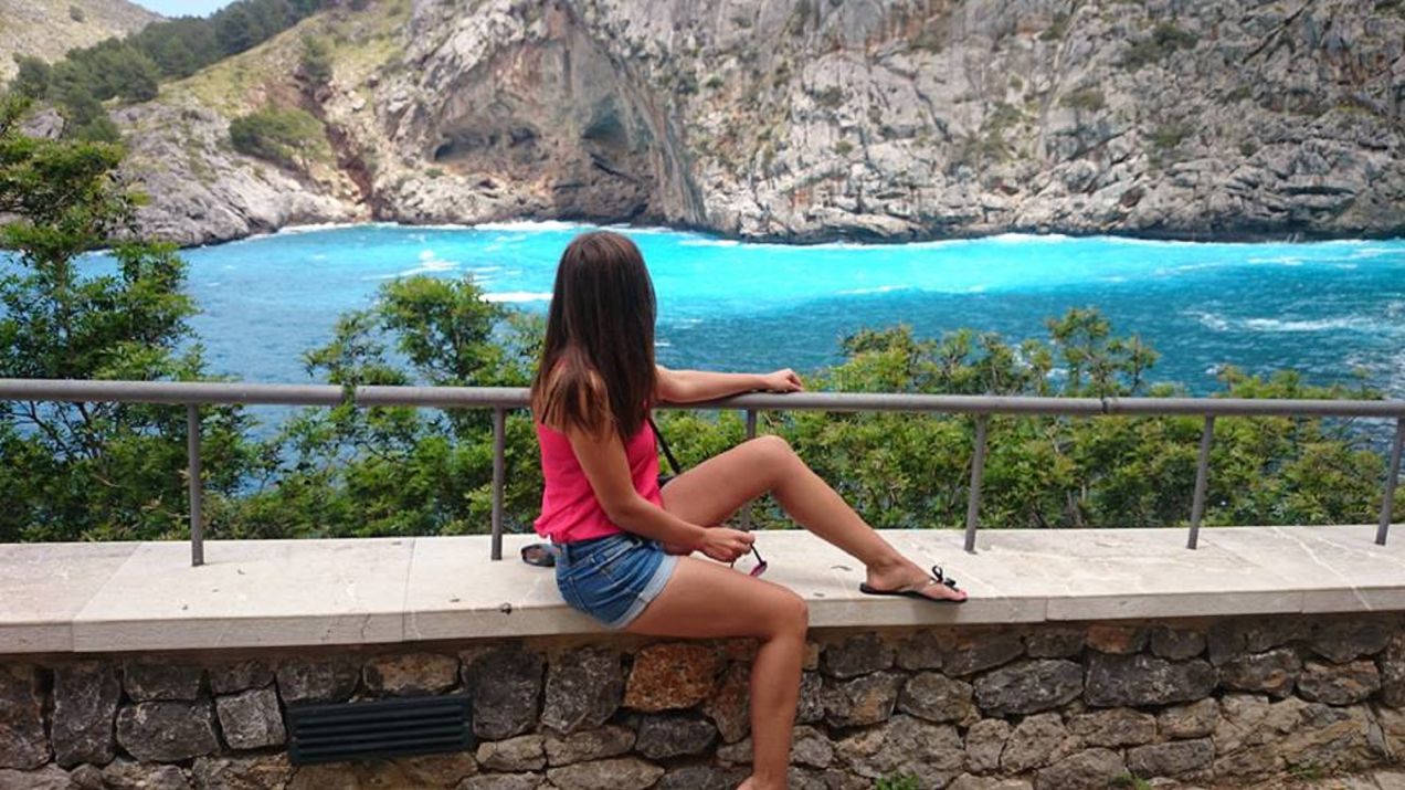 Dziewczyna siedząca na murku. Patrzy na zatoczkę Sa Calobra na Majorce