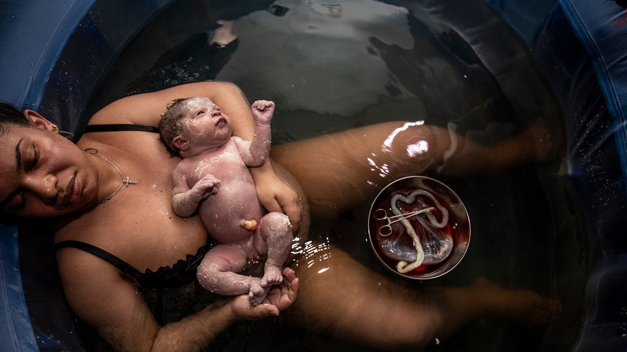 Wyczerpana po porodzie córki Kim Bonsignore leży w basenie porodowym w swoim salonie.