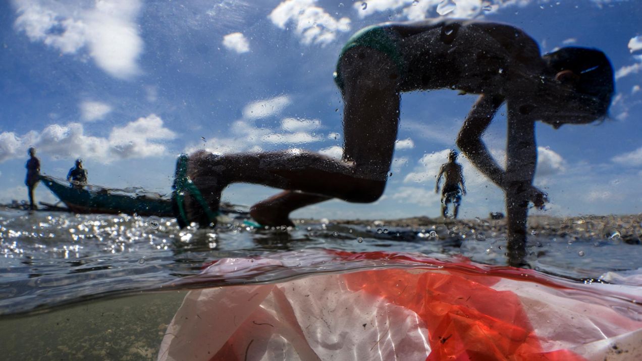 Dzieci bawią się nad brzegiem Zatoki Manilskiej, zanieczyszczonej odpadami (Photograph by Randy Olson, Nat Geo Image Collection)