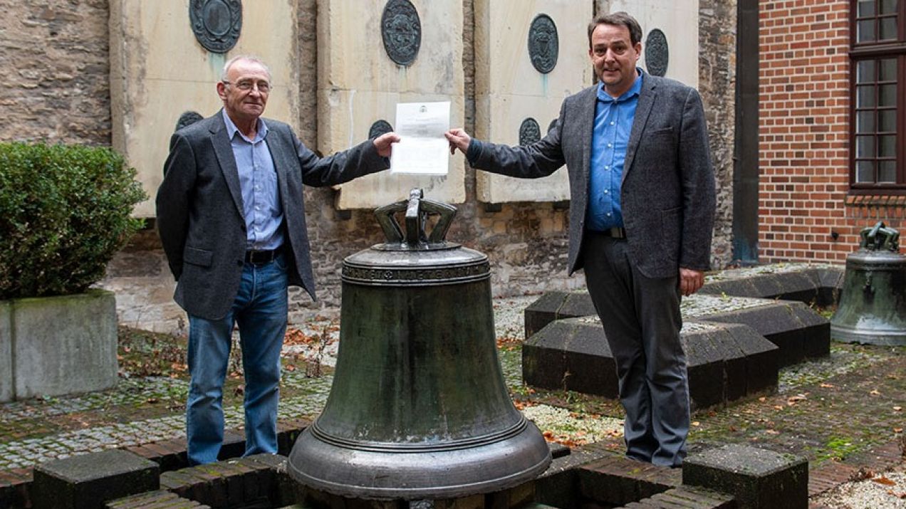 Hans Manek (po lewej) i prof. Thomas Flammer vor der Glocke pozują przy zabytkowym dzwonie (fot. bistum-muenster.de)
